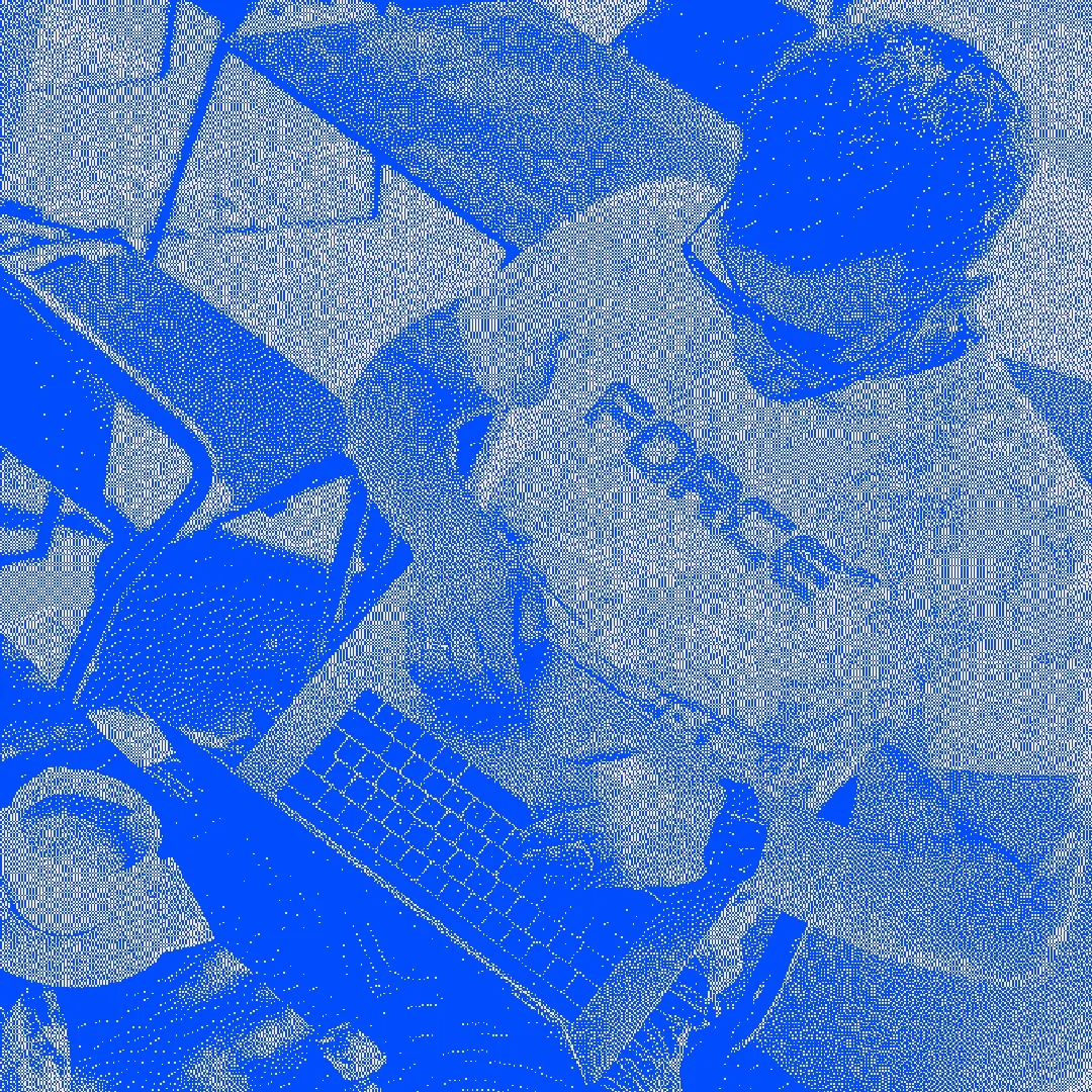 A designer working at a desk with a laptop and notebook